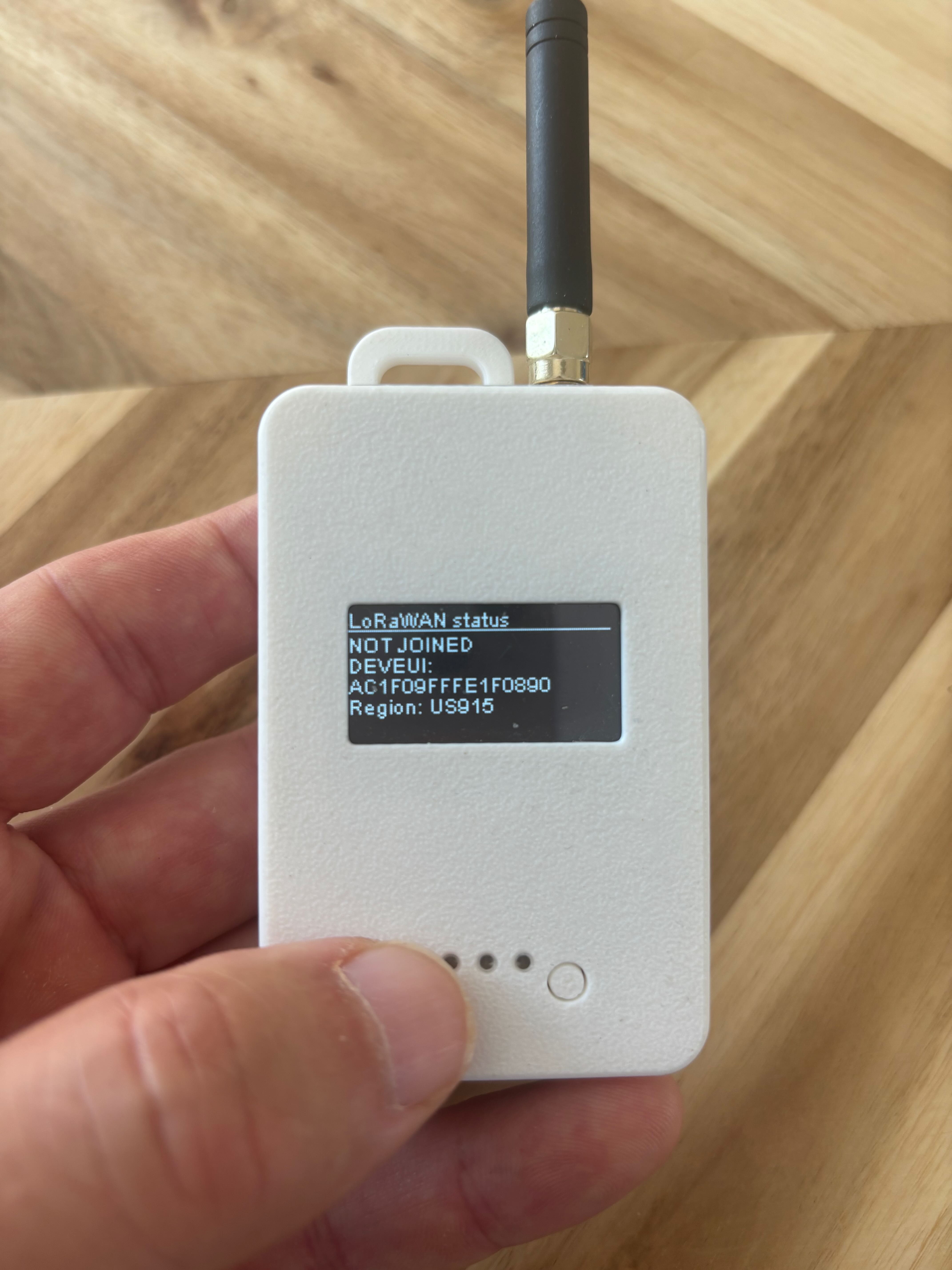 Écran de l'appareil Loptimizer Pocket Tester affichant le statut LoRaWAN, le DevEUI et Region: US915.